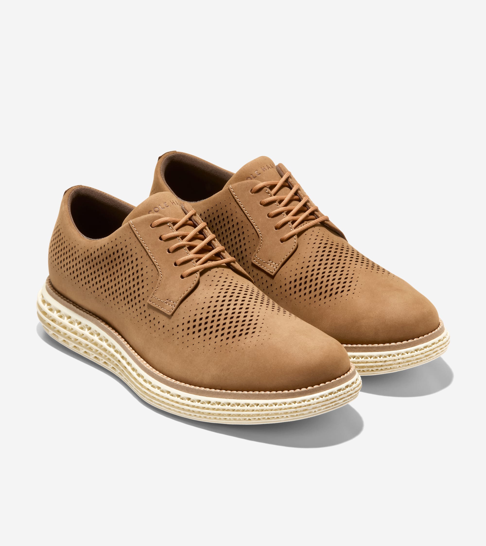 Tan perforated leather Oxfords with matching laces and a thick, textured cream-colored sole.
