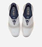 Pair of light gray oxfords with laser-cut perforations, navy blue collar and tongue, light gray laces, and off-white ridged s
