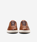 Brown leather sneakers with perforated uppers, dark brown laces, and off-white soles.