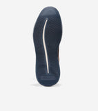 Dark blue ribbed sneaker sole with a cream wavy line and Cole Haan 6.ZERØGRAND branding at the heel. Brown upper visible.