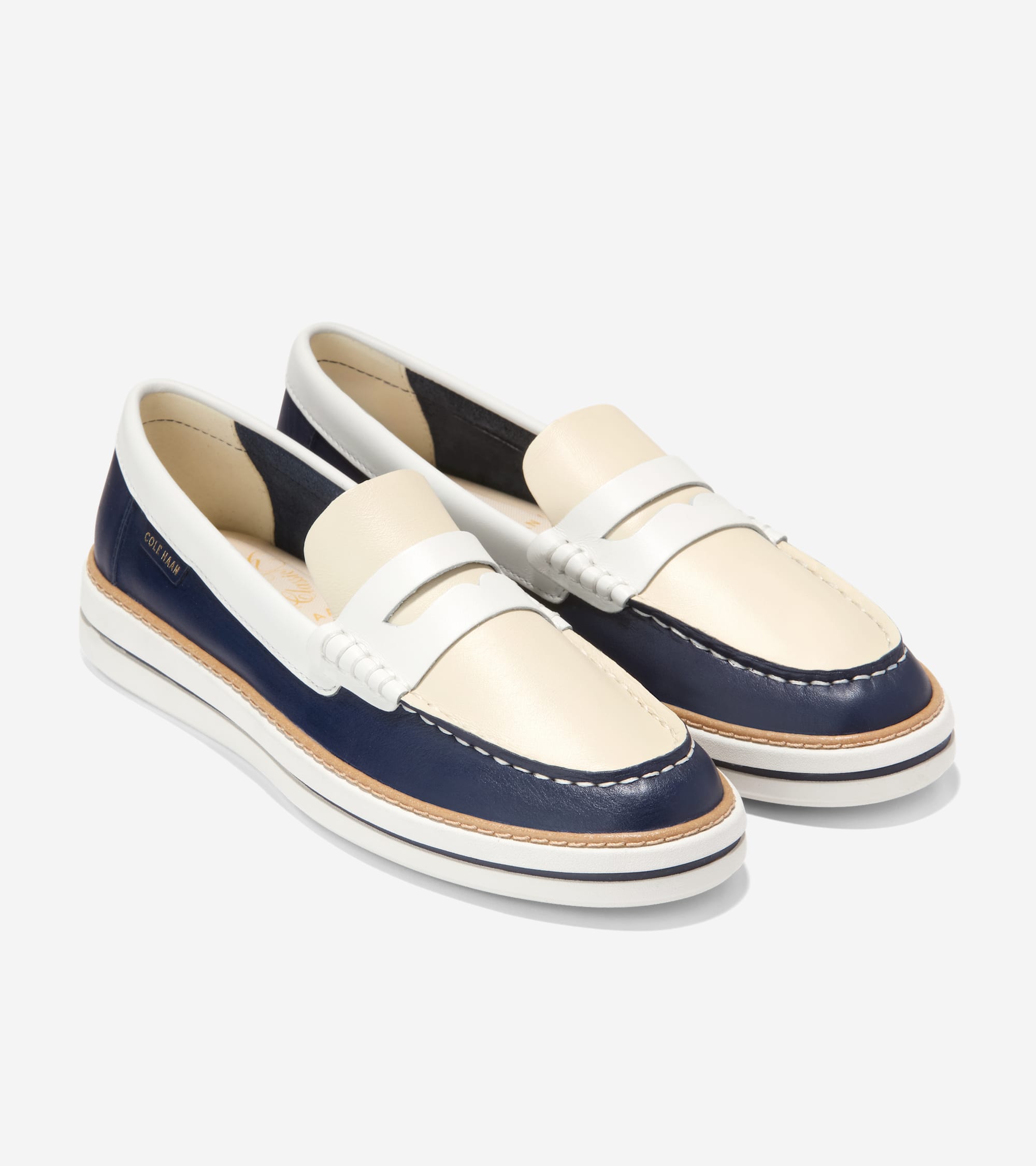 Pair of two-tone navy blue and off-white leather penny loafers with white stitching, white trim, and a platform sole.