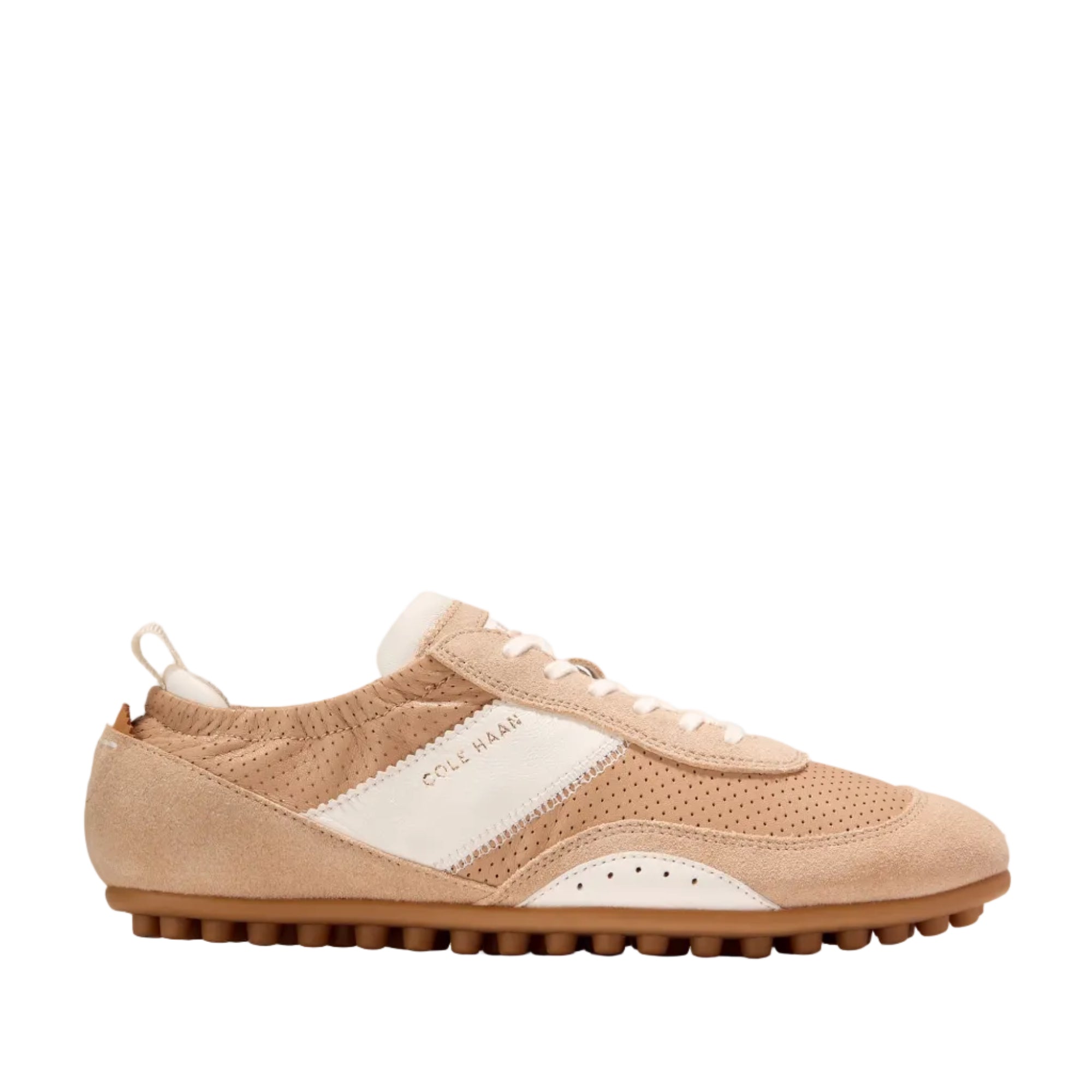 Light beige Cole Haan GrandPrø Travina sneaker with white side stripe, perforated panels, and a brown studded rubber sole.