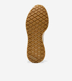 Brown rubber sneaker sole with diamond tread pattern. 'COLE HAAN GRAND 360' embossed at the heel. Light beige midsole.