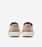 Pair of light beige leather oxfords with perforated broguing, embossed 'C' logo on the heel, and thick cream soles, viewed fr