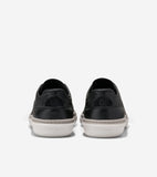 Pair of black leather sneakers with textured uppers, light grey soles, and a thin grey stripe. Cole Haan logo embossed on hee