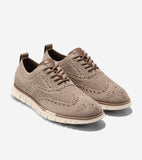 Tan knit wingtip oxfords with perforated brogue details, brown leather eyelets, matching laces, and a cream ridged sole.