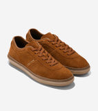 Brown suede sneakers with matching laces, light brown rubber soles, and a smooth brown collar trim. "COLE HAAN" is on the sid