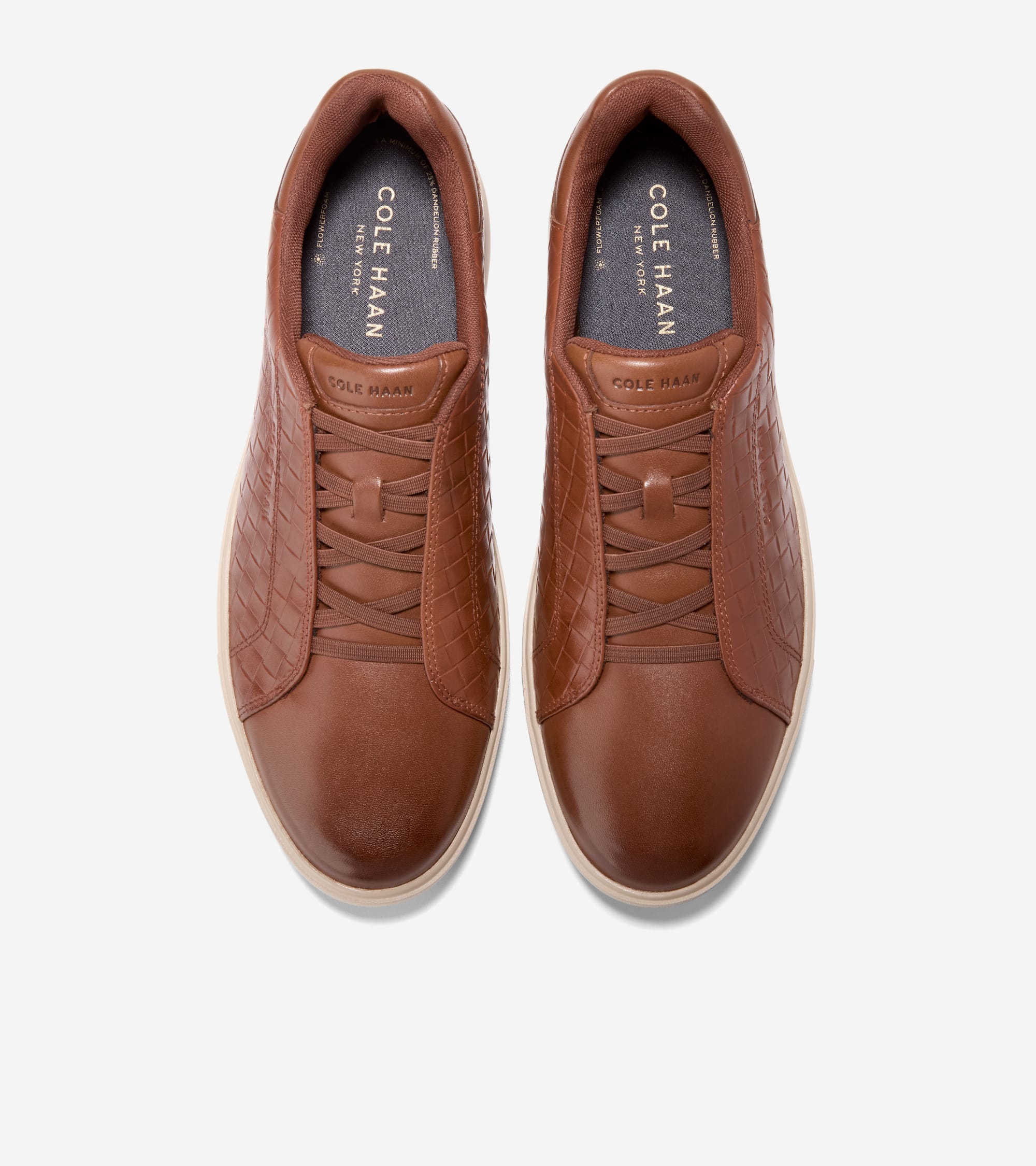 Brown leather slip-on sneakers with basket-weave textured sides, smooth toe, decorative laces, and cream soles.