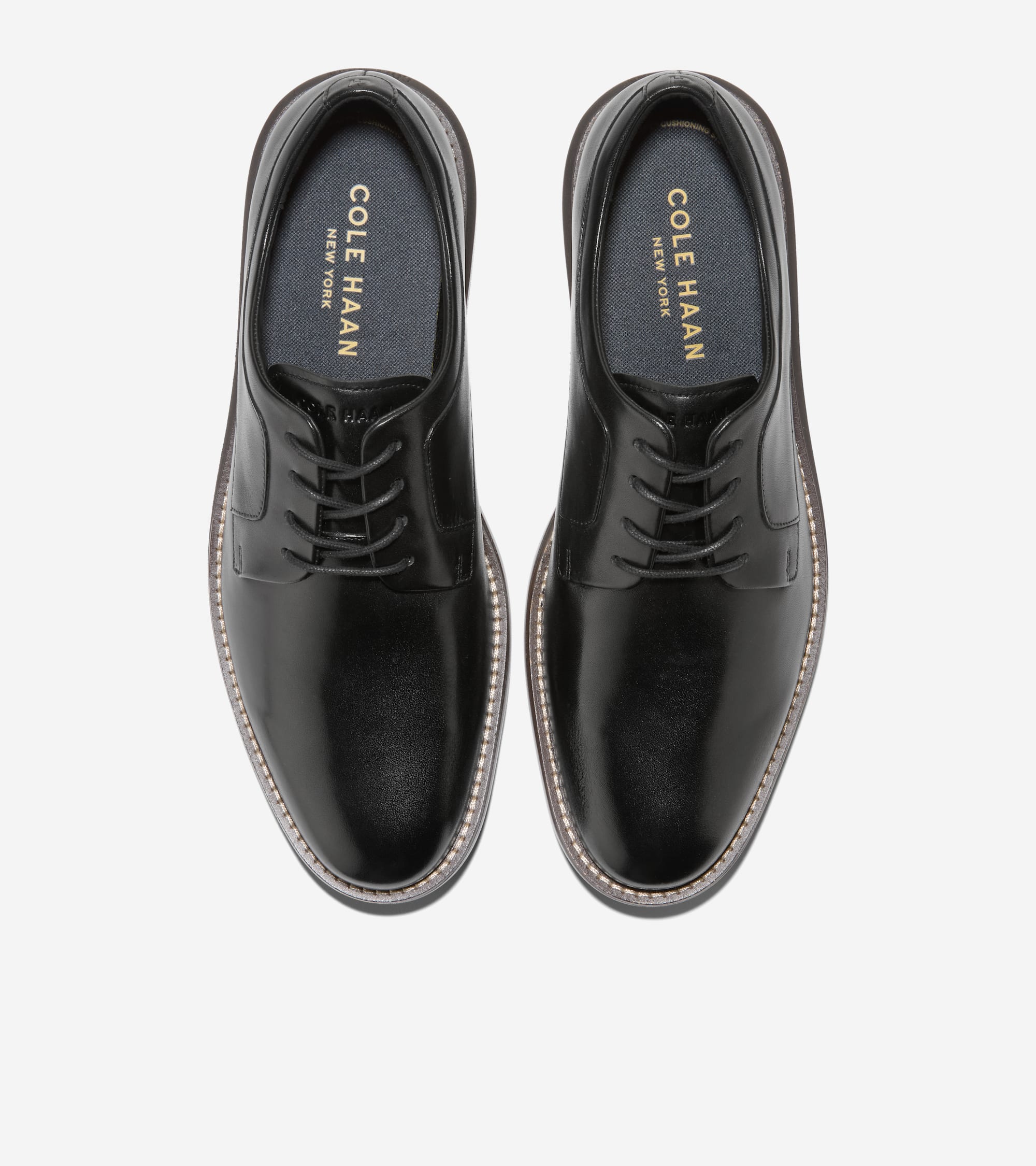 Pair of black leather plain-toe oxfords with black laces, light stitching around the sole, and 'COLE HAAN NEW YORK' on the in