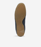 Bottom view of a navy suede sneaker with a light brown gum sole featuring a diamond tread pattern.