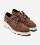 Pair of brown knit oxford shoes with brogue details, brown laces, textured brown heel accents, and thick white platform soles