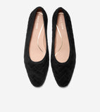 Pair of black quilted ballet flats with pointed toes. They feature a herringbone quilted pattern and light tan insoles with g