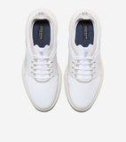 Pair of white mesh sneaker oxfords with light beige soles, perforated sides, and white laces. Dark blue insoles with gold-ton