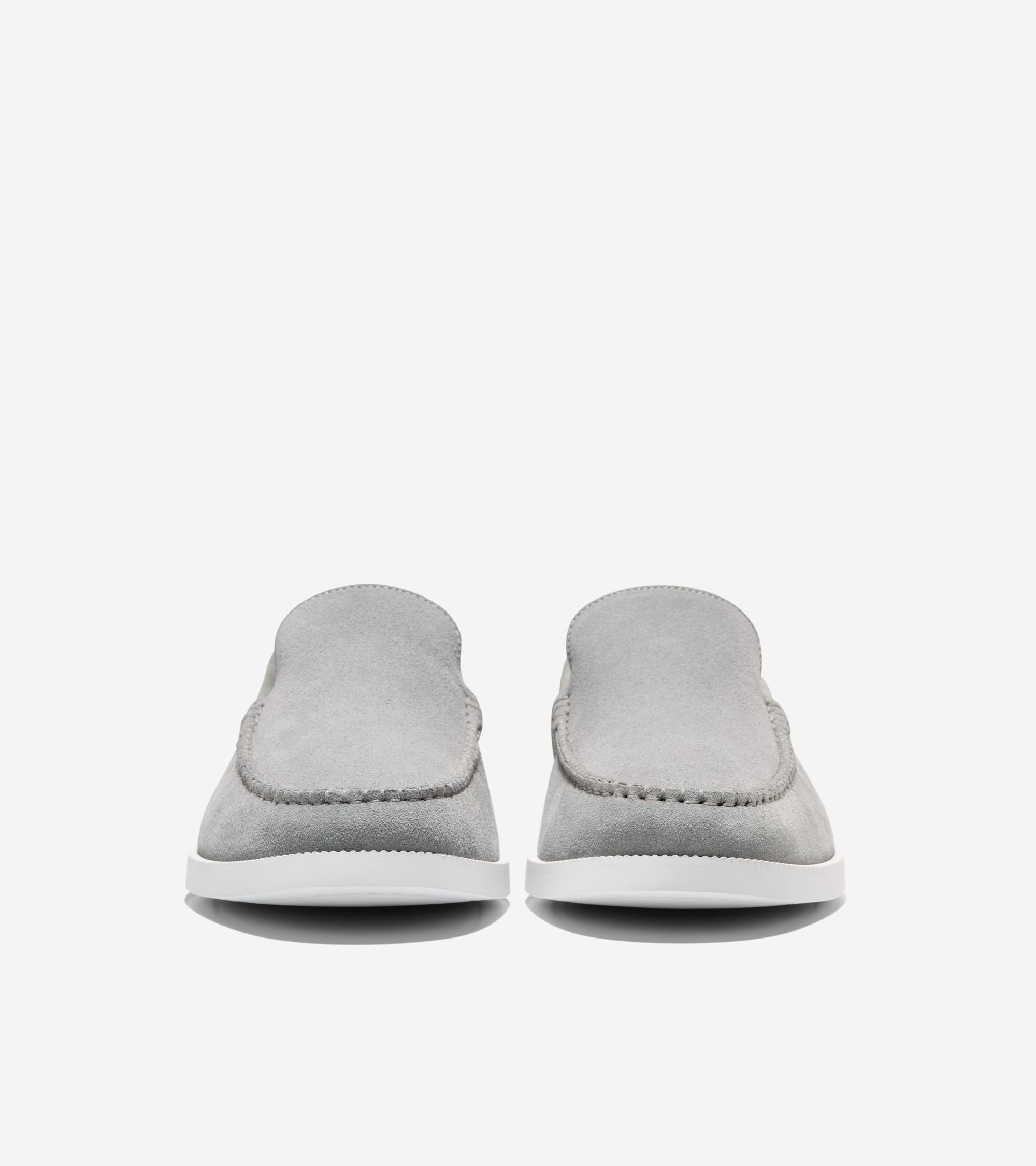 Pair of light gray suede loafers with moc-toe stitching and white flat soles.
