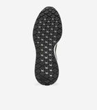 Black sneaker sole with a textured diamond pattern, some diamonds featuring white X-shapes, a white edge, and 'Cole Haan Gran