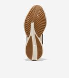 Brown and beige sneaker sole with wavy, ribbed brown rubber traction pads. Cole Haan and Grand.ØS logos are visible.
