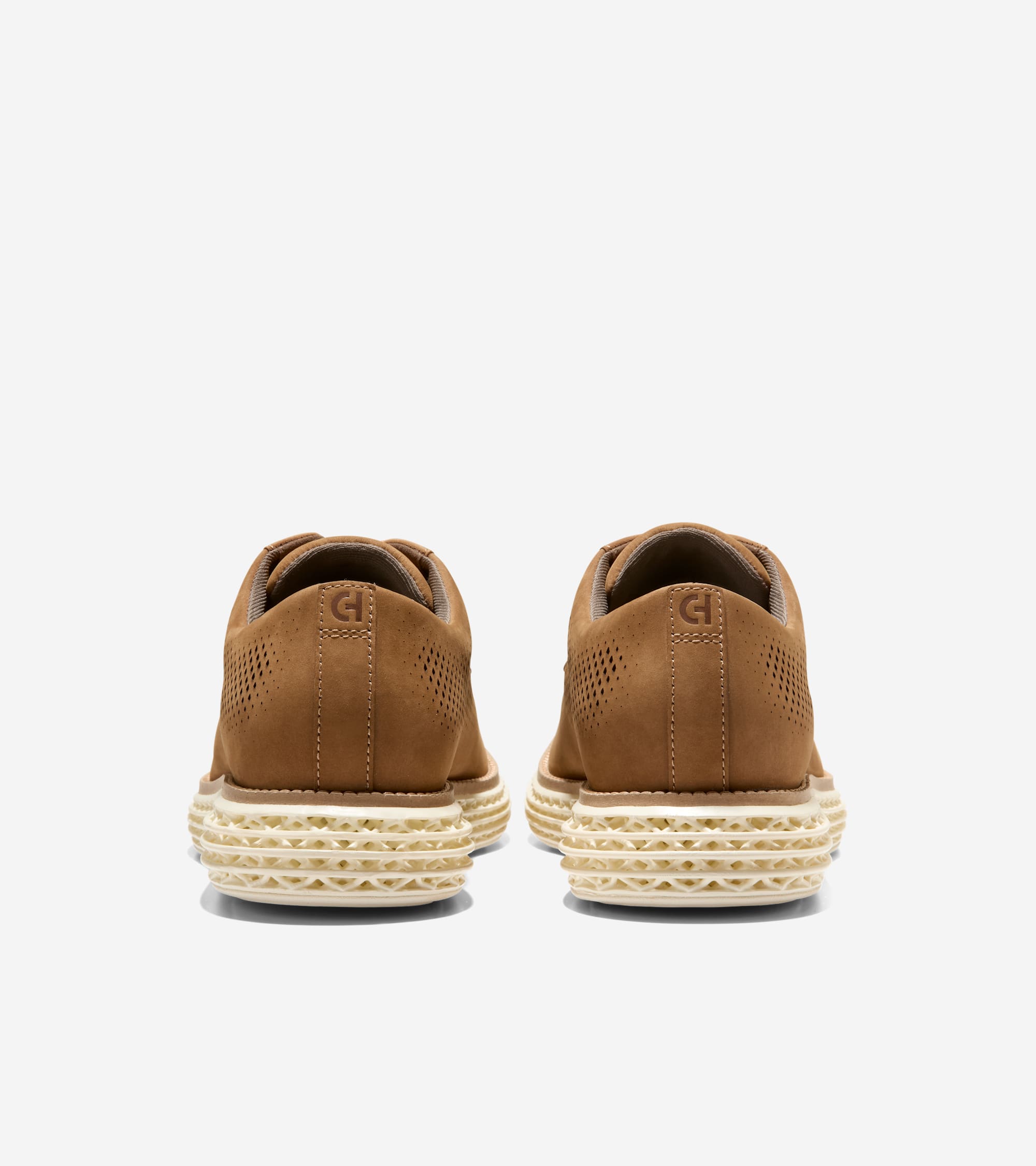Pair of brown perforated oxfords with a "CH" logo on the heel and thick, textured cream soles.