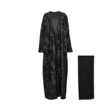 Front view of a black Bazzah Couture open abaya with metallic leaf patterns over a black satin inner dress.