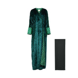 Front view of an emerald green crushed velvet abaya by Bazzah Couture featuring patterned green and white cuffs and a matching black Sheila.