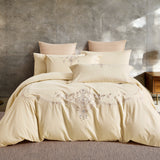 Frontal view of a luxury bed set with sophisticated grey and tan botanical embroidery.