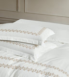 Deluxe white pillowcases with precision-stitched geometric gold patterns and professional flanged edges.
