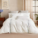 Front-facing view of a luxury bed set with pink and green wildflower embroidery.
