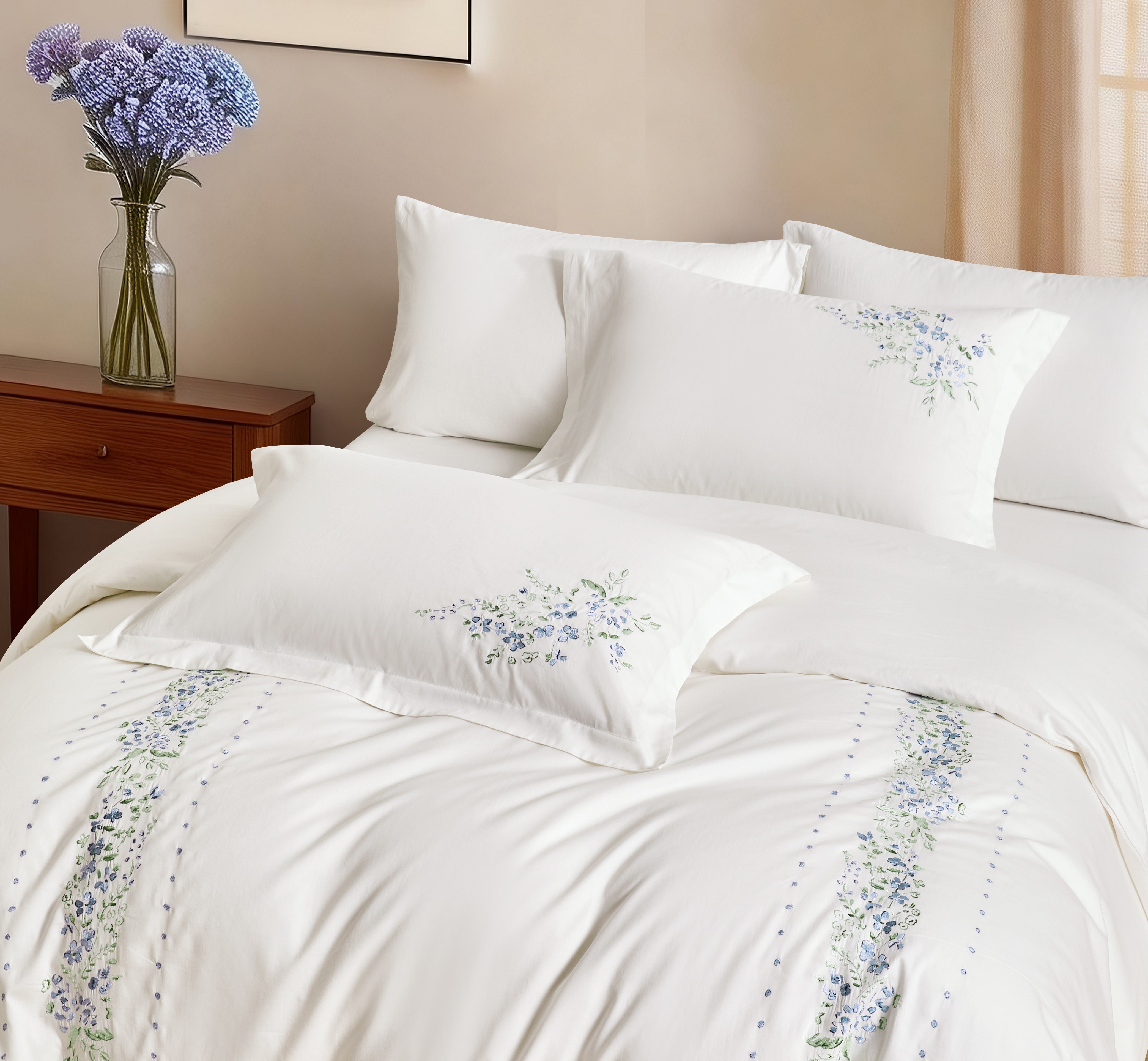 Full bedroom scene with white floral embroidered bedding and a modern wood headboard.