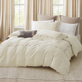 Close-up of white pillowcases featuring elegant gold-threaded vertical leaf embroidery.