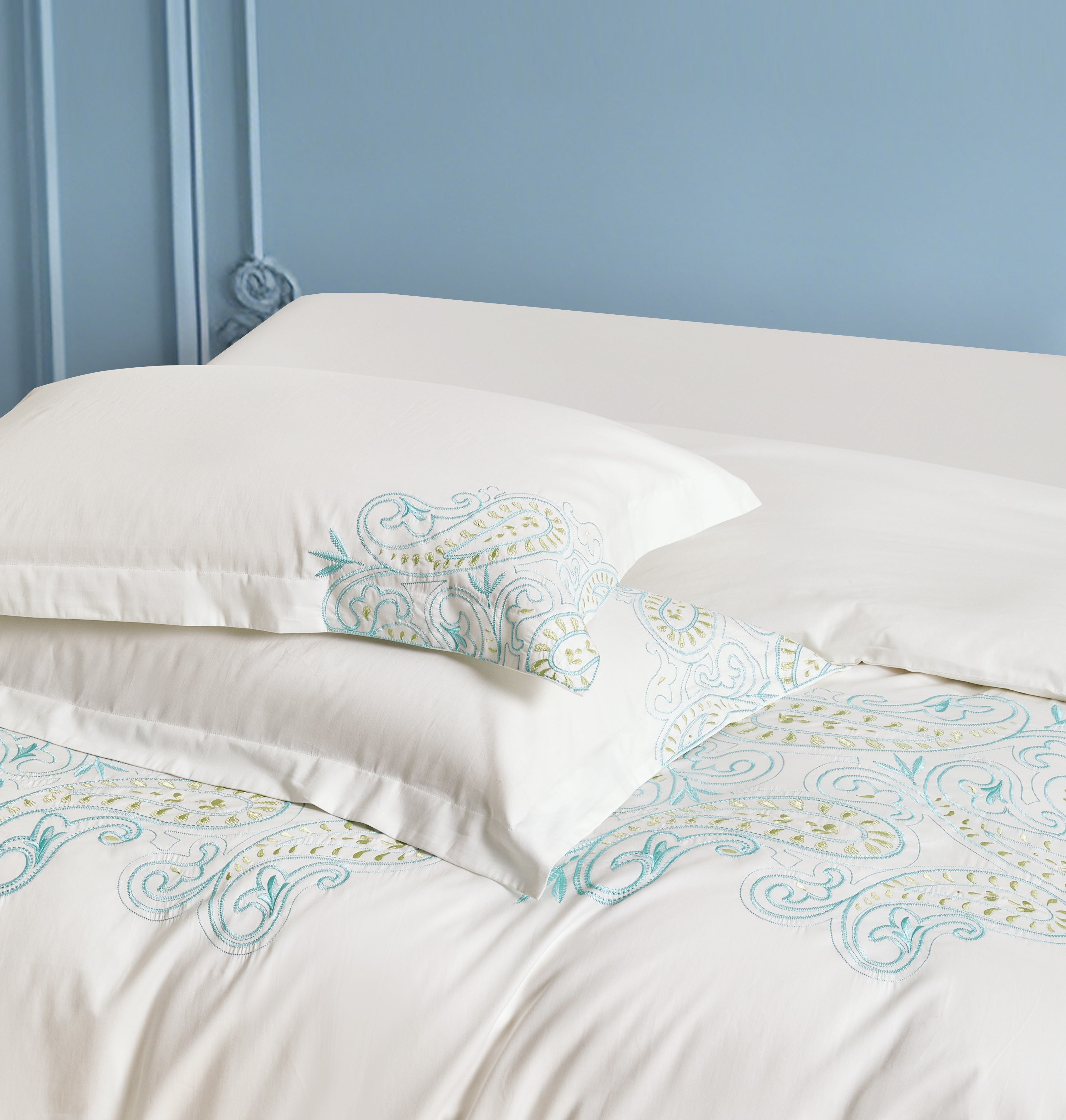 White pillowcases featuring elegant vertical orange flower and vine embroidery.