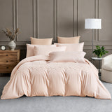 Full view of white luxury bedding with gold geometric border embroidery in a modern room.