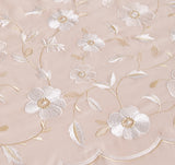 Detailed macro shot of high-density gold geometric embroidery on crisp white fabric.