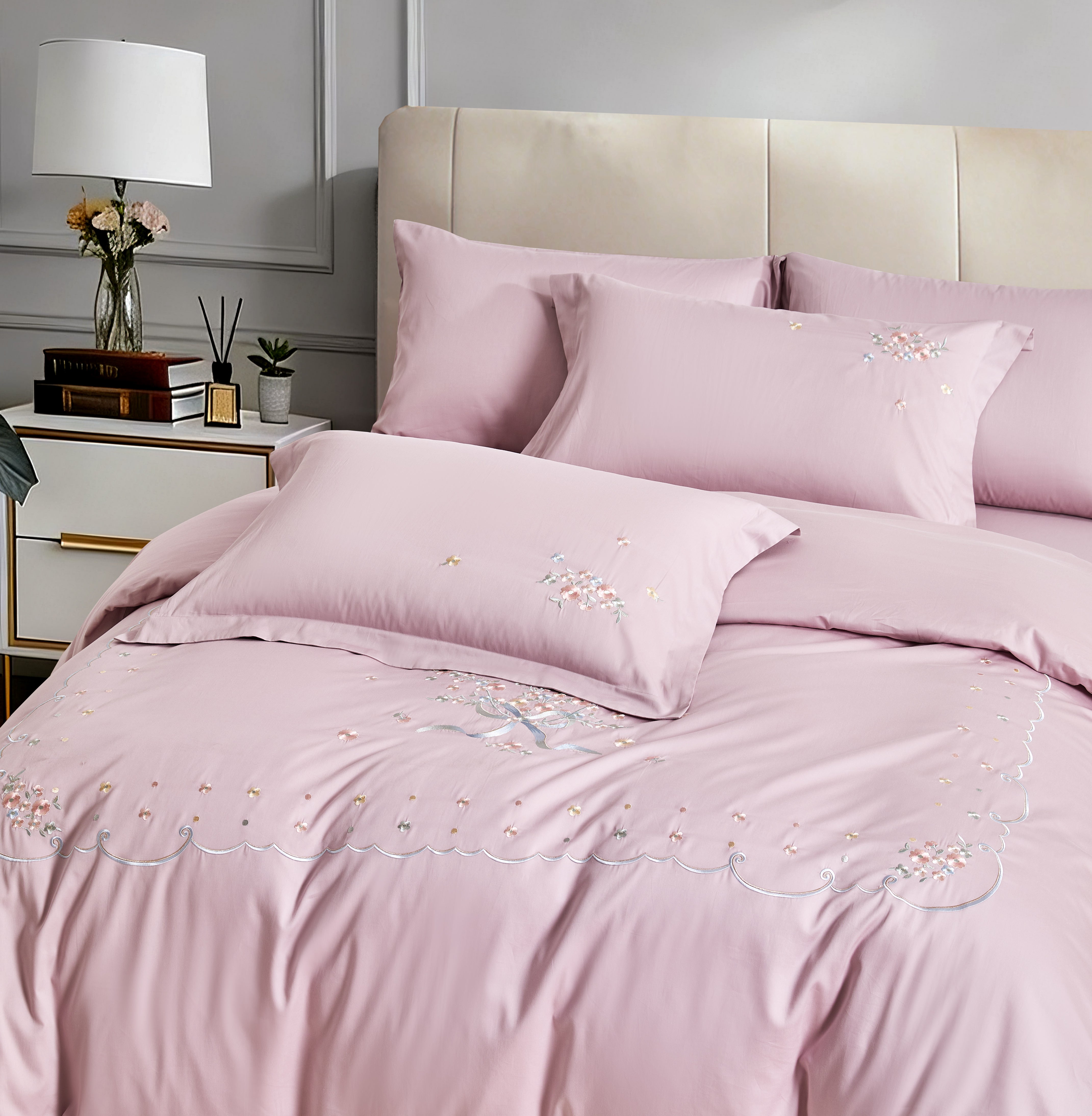 Angled view of a white duvet cover with a decorative grey botanical embroidered border.