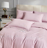 Angled view of a white duvet cover with a decorative grey botanical embroidered border.