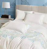 White pillowcases featuring elegant vertical orange flower and vine embroidery.