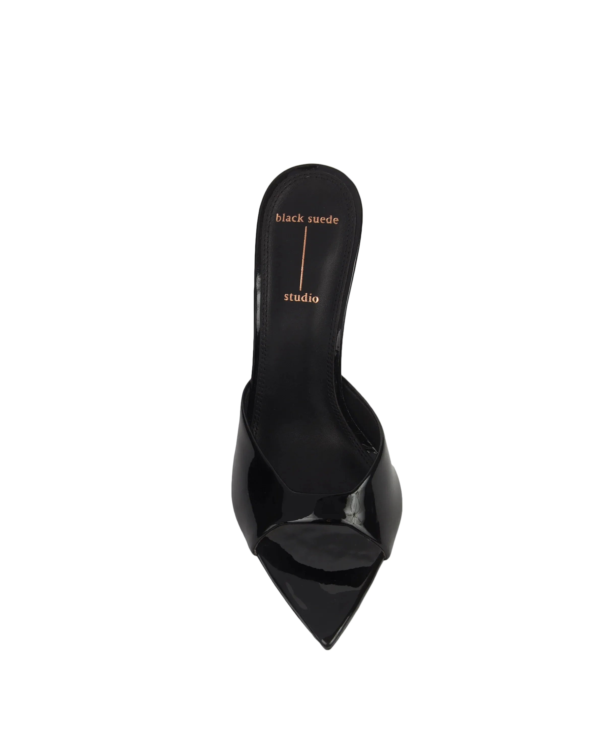 Top-down view of Brea mule, showing the "black suede studio" logo on the black footbed and the architectural pointed toe.