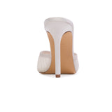 Rear view of the BLACK SUEDE STUDIO Forever 100 white mule emphasizing the stiletto heel and satin counter.