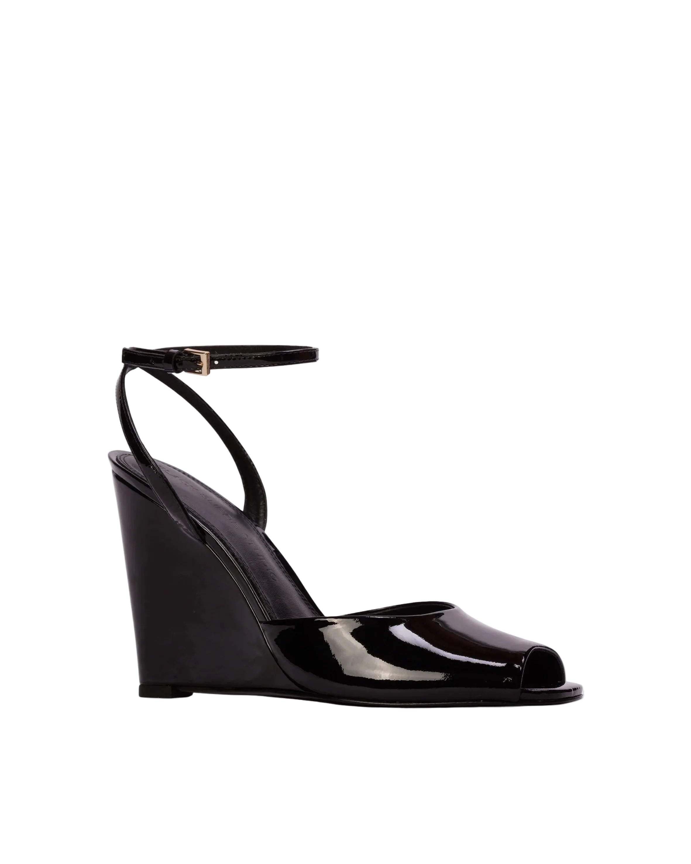 Three-quarter view of an elegant black patent wedge heel against a neutral background, showcasing the peep-toe front and d'Orsay side styling.