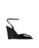 Profile view of a black high-gloss patent leather wedge sandal by Black Suede Studio, highlighting the tall sculpted wedge and the slim adjustable ankle strap.