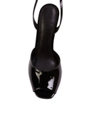 Overhead shot of a Black Suede Studio black patent leather wedge sandal showing the peep-toe design and the black leather insole with the brand name.