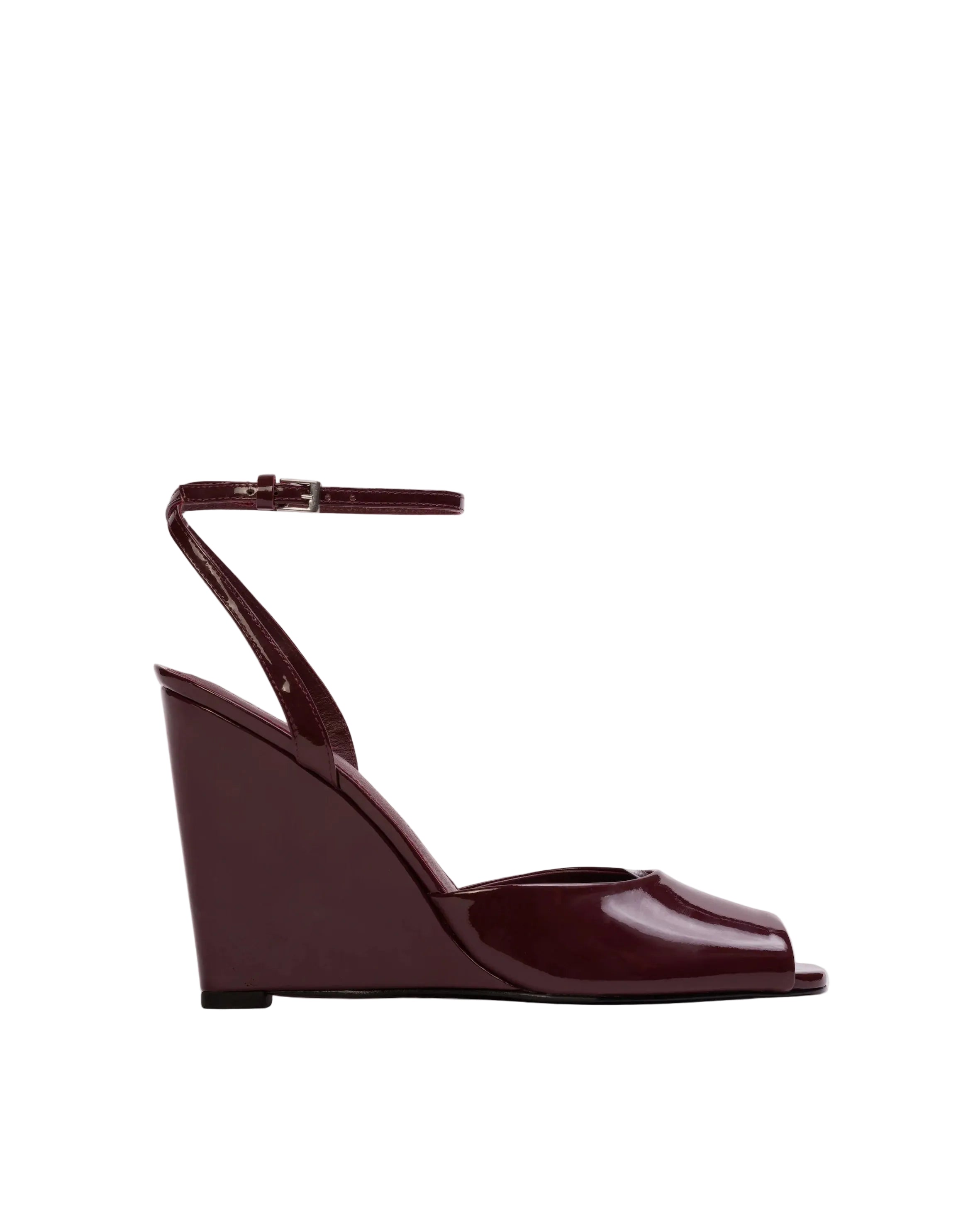 Profile view of a raisin high-gloss patent leather wedge sandal by Black Suede Studio, highlighting the tall sculpted wedge and the slim adjustable ankle strap.