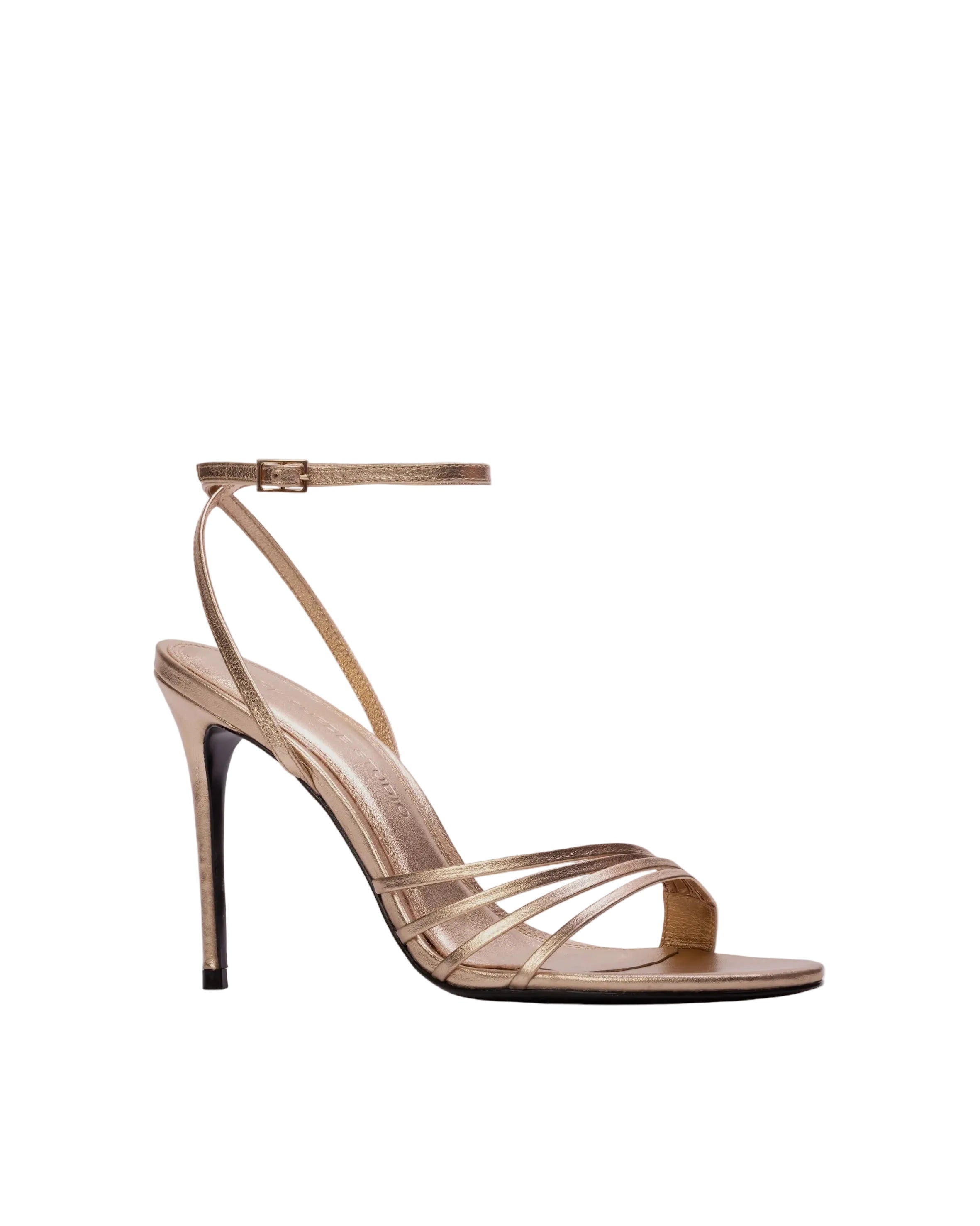 Three-quarter view of a cream and black cap-toe slingback shoe highlighting the elegant silhouette and contrasting patent leather toe.
