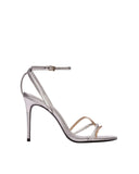 Profile of a Black Suede Studio silver metallic stiletto sandal featuring an adjustable ankle strap and a thin champagne gold accent strap across the toes.