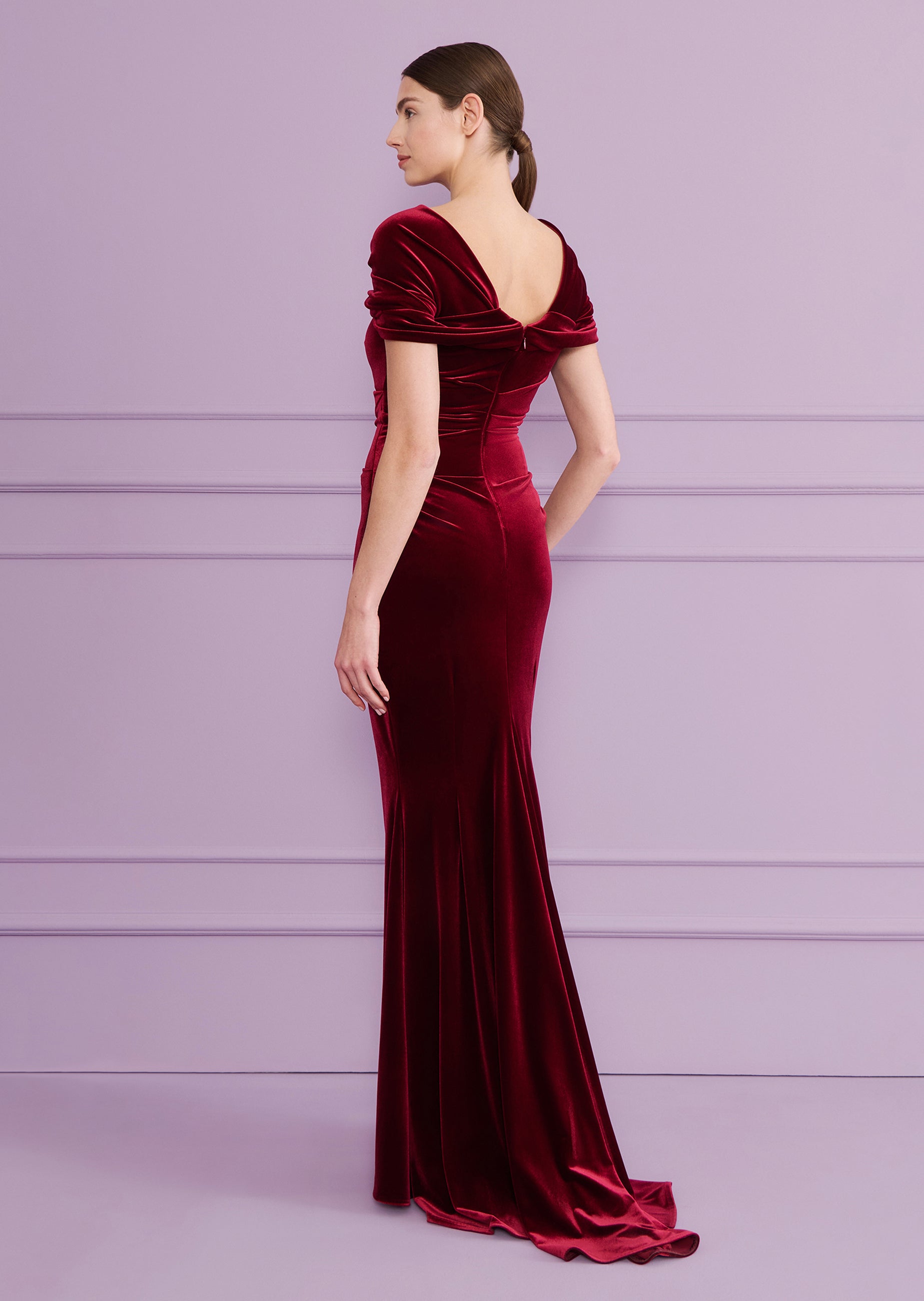Burgundy velvet long dress with off-the-shoulder draped sleeves, a V-neck back, and a fitted silhouette with a flared hem.