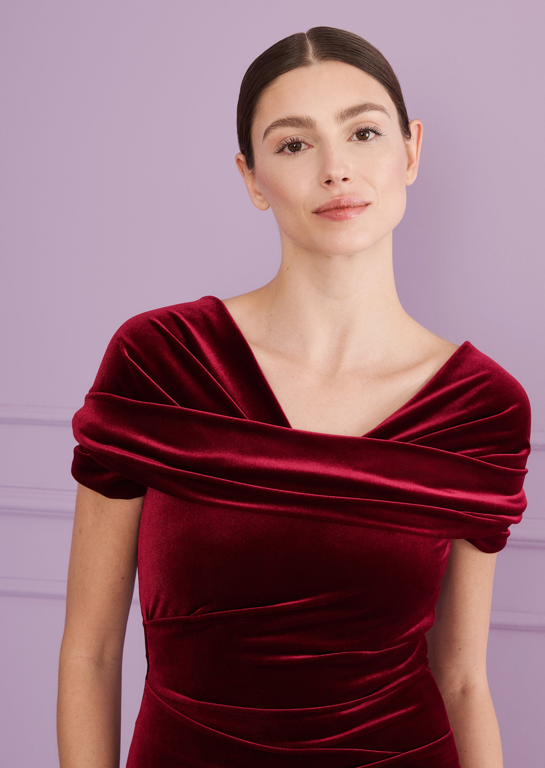 Burgundy velvet long dress with an off-the-shoulder draped neckline and ruched bodice.