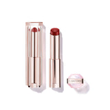 Lancome Lip Idole lipstick in a deep red shade, with a clear ribbed cap and rose gold-toned metallic base, alongside a small