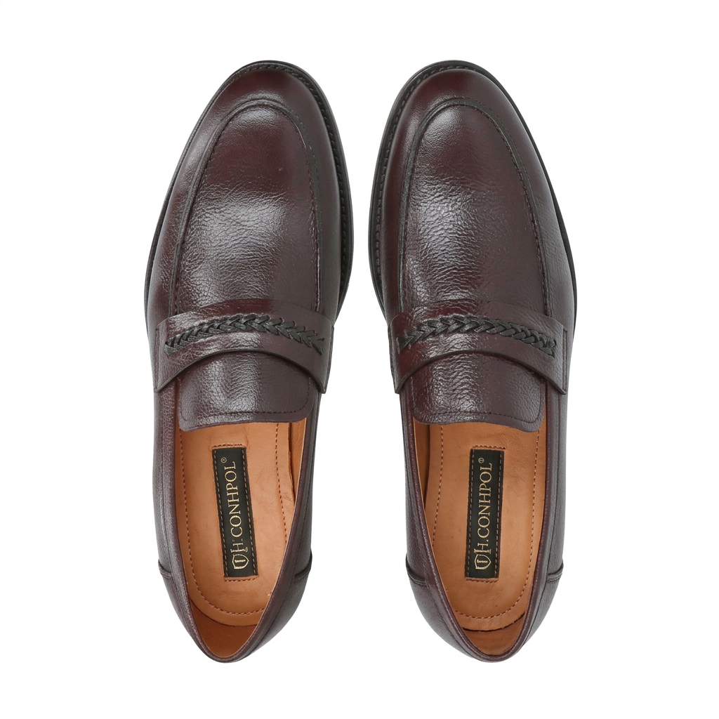 Pair of dark brown pebbled leather loafers with almond toes and a braided strap across the vamp. Black soles.