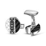 Silver-toned cufflinks with black carbon fiber. One has a round face with 'S' logos and geometric pattern. The other has a cu
