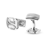 Pair of silver-toned cufflinks. One features an intertwined 'SH' monogram. The other has a rectangular top engraved 'SAINT HO