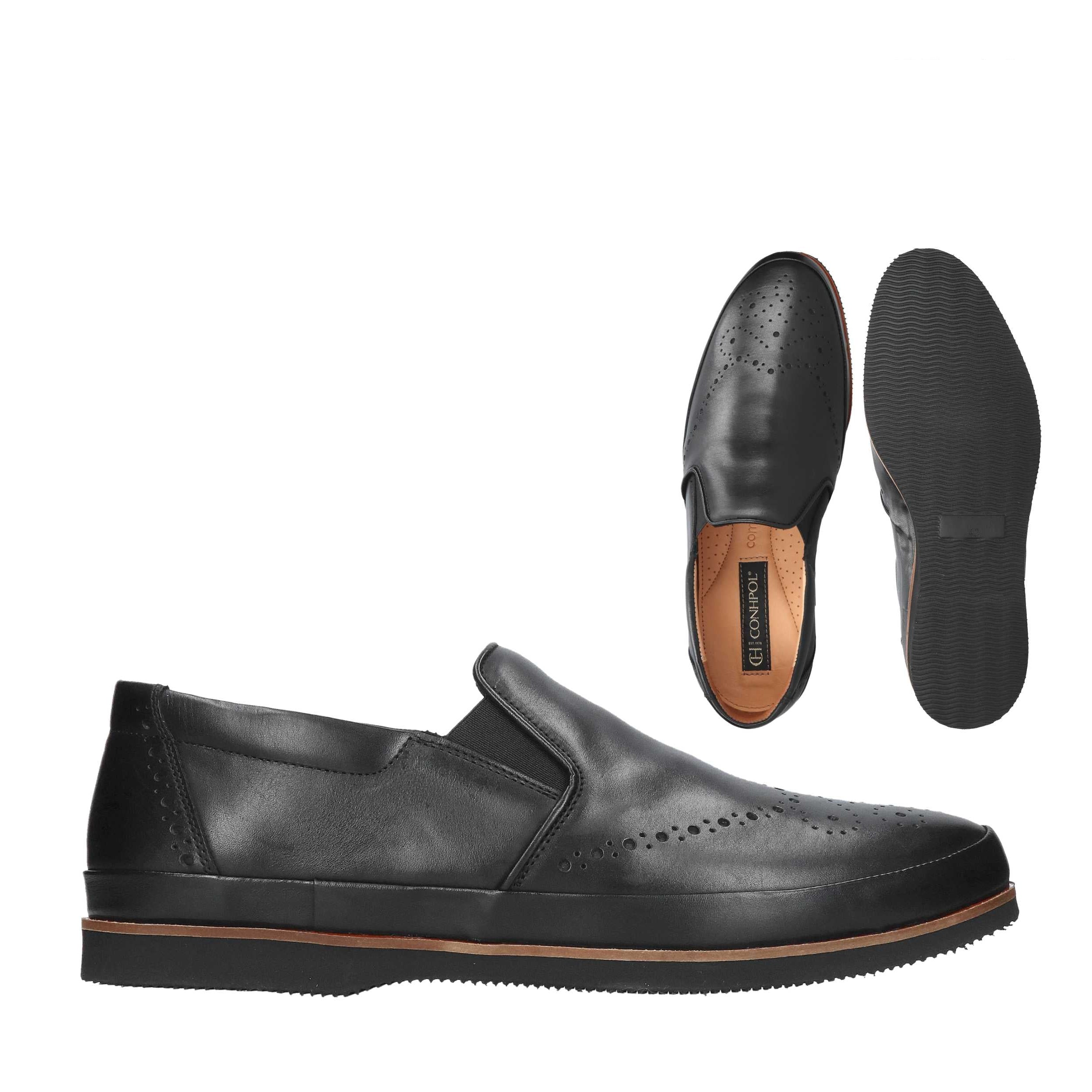 Black leather slip-on shoes with brogue perforations on the toe and sides, elastic goring, and a thick black sole with a brow