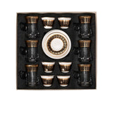 CASA BLU 18-piece luxury beverage set in a black display box, featuring six clear tea glasses with gold rims, six white and gold Arabic coffee cups, and stacked gold-patterned saucers.